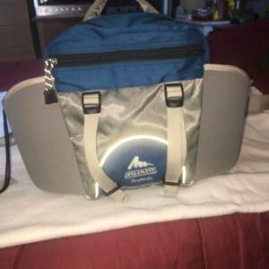 May include: A blue and silver Gregory backpack with reflective accents and the text "Gregory" and "Sports" on the front.