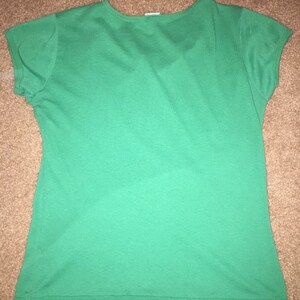 May include: A solid green short-sleeved t-shirt with a v-neck.