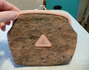 May include: A brown and pink fabric coin purse with a triangular logo that says "bonjour" in white lettering.