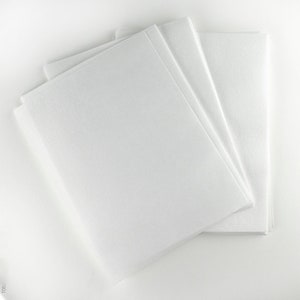 May include: Three white sheets of paper stacked on top of each other. The sheets are smooth and have a slightly textured surface.