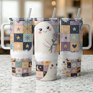 May include: Three stainless steel tumblers with white handles and lids. The tumblers feature a patchwork design with stars, hearts, and spiderwebs. One tumbler has a cartoon ghost holding a flower. Each tumbler includes a silver straw.