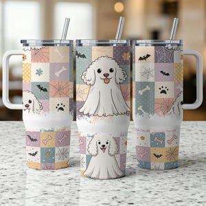 Può includere: Tre bicchieri in acciaio inossidabile con manici e coperchi bianchi. Ogni bicchiere presenta un design di barboncino dei cartoni animati e un motivo patchwork con pipistrelli, ragnatele e impronte di zampe. I bicchieri includono una cannuccia d'argento.