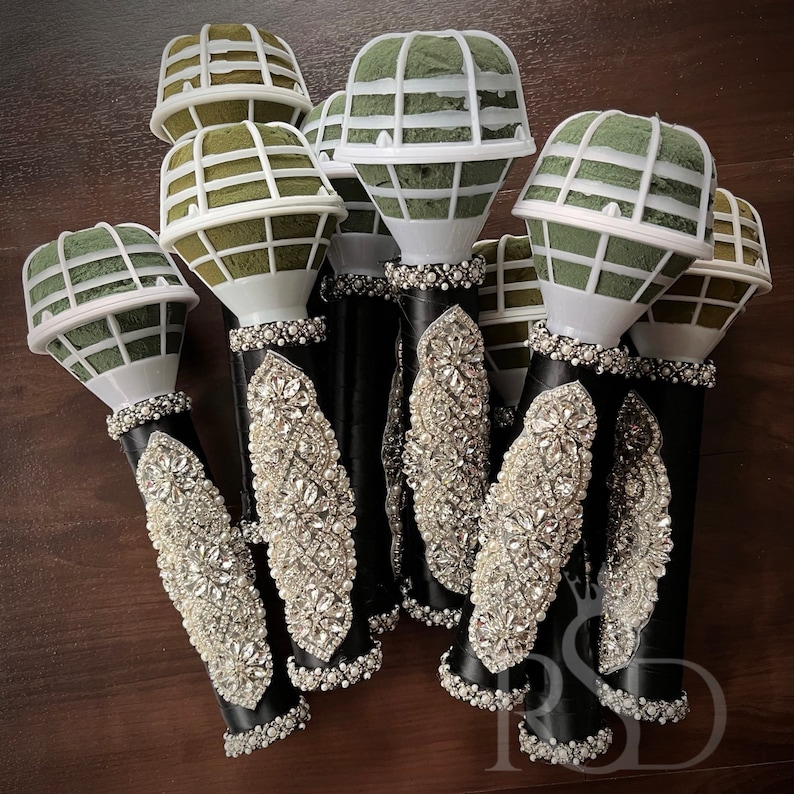 Puede incluir: Un grupo de siete porta-ramos florales negros y blancos con un inserto de espuma verde. Los soportes est&aacute;n decorados con diamantes de imitaci&oacute;n.