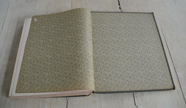 Op de afbeelding: Een gesloten boek met een groene en witte patroon op de omslag. Het boek ligt open op een licht houten oppervlak.