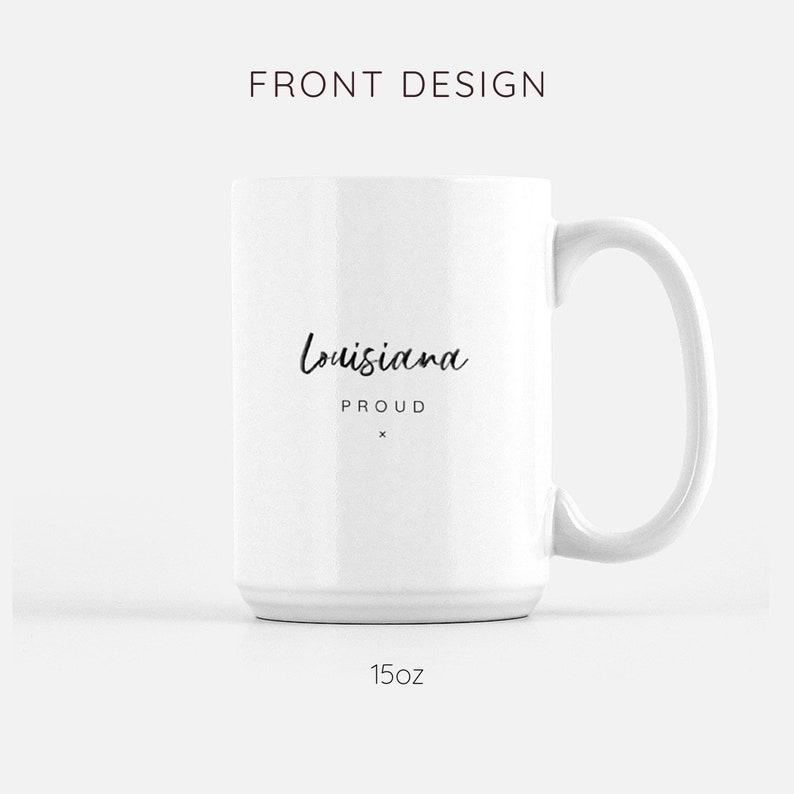 May include: White ceramic mug with a black handwritten design that says "Louisiana Proud" on the front. The mug is 15 ounces.