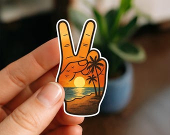 May include: A sticker in the shape of a hand making the peace sign, with a sunset beach scene inside. The design features a yellow sun, palm trees, and birds against an orange and blue background. The sticker has a white border.