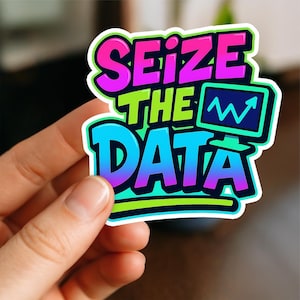 Könnte beinhalten: Ein farbenfroher Aufkleber mit dem Text "Seize the Data" in einer kräftigen, stilisierten Schriftart. Das Design zeigt eine Computermonitor-Grafik mit einem ansteigenden Liniendiagramm. Der Aufkleber hat einen Farbverlauf aus Blau, Lila, Grün und Pink.