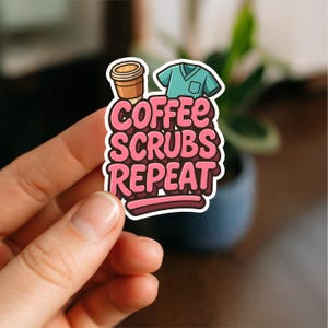 May include: A sticker with the text "Coffee Scrubs Repeat" in pink, with a coffee cup and teal scrubs graphic. The sticker is held by a hand.