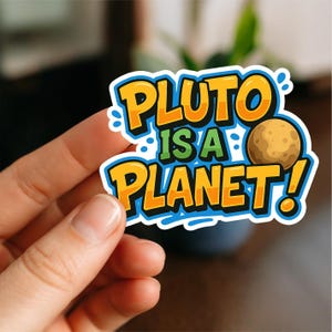 May include: A vibrant sticker proclaiming "PLUTO IS A PLANET!" in orange and green, featuring a cartoon Pluto. The sticker has a blue border. It is held by a hand.