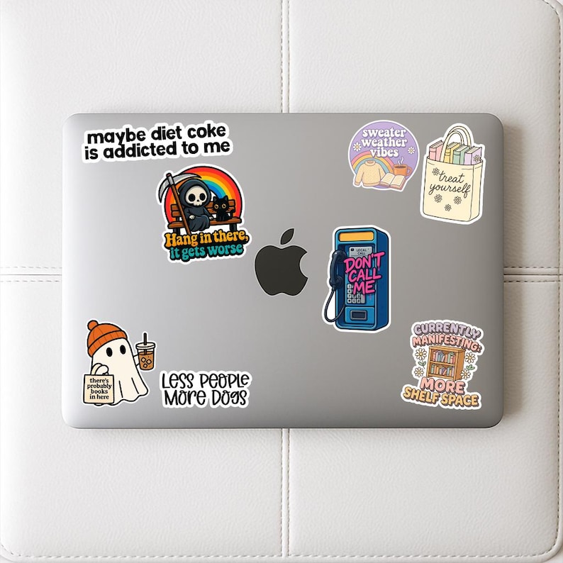 a laptop with various stickers and stickers on its surface.