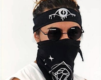 May include: A person wearing a black bandana with a white diamond design and a white eye with a lightning bolt graphic on a black headband.
