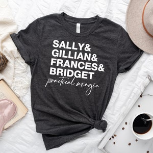 May include: A dark grey t-shirt with white text that reads "Sally & Gillian & Frances & Bridget practical magic".