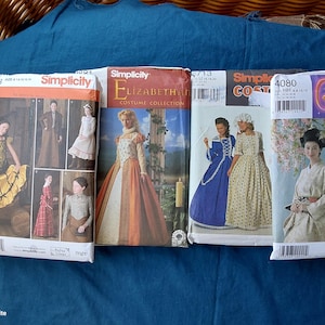 May include: Four Simplicity sewing pattern envelopes for costumes. The first shows historical outfits, the second an Elizabethan collection, the third colonial-style dresses, and the fourth a kimono. Each envelope features illustrations of the finished garments.