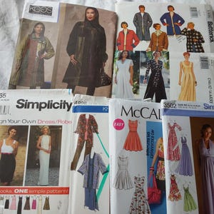 Peut inclure: Une collection de huit pochettes de patrons de couture de marques telles que Simplicity, Butterick et McCall's. Les pochettes présentent diverses illustrations de vêtements, dont des robes, des robes de chambre et des vestes, avec du texte imprimé.