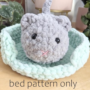May include: A light green crocheted pet bed with a gray crocheted cat toy inside. The text "bed pattern only" is written below the bed.