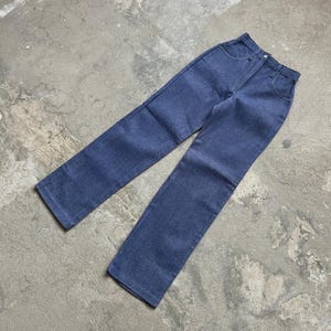 Op de afbeelding: Een spijkerbroek van blauwe denim met een klassiek ontwerp met vijf zakken. De jeans heeft een rechte pijp en een knoop- en ritssluiting. De denim heeft een medium wassing en de jeans liggen plat op een betonnen ondergrond.