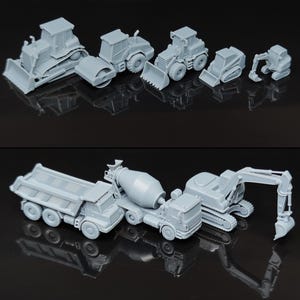 May include: A collection of small, gray construction vehicles, including a bulldozer, road roller, front-end loader, skid steer, excavator, dump truck, cement mixer truck, and tracked excavator. The vehicles are arranged on a reflective black surface.