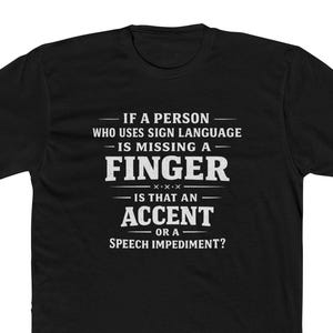 May include: A black short-sleeved t-shirt featuring white text that reads: IF A PERSON WHO USES SIGN LANGUAGE IS MISSING A FINGER IS THAT AN ACCENT OR A SPEECH IMPEDIMENT? The design is centered on the chest with a crew neckline and standard fit.