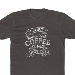 May include: A dark gray t-shirt with a white graphic that says "I just wanna drink coffee until further notice".