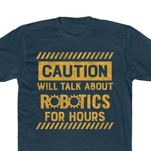 May include: A dark blue t-shirt with a yellow caution sign that reads "CAUTION WILL TALK ABOUT ROBOTICS FOR HOURS".