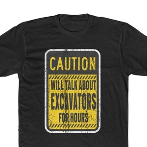 May include: Black t-shirt with a yellow and black caution sign that reads "CAUTION WILL TALK ABOUT EXCAVATORS FOR HOURS".