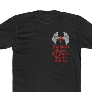 May include: Black t-shirt with a white angel wing design and a red cross. The text "Non Nobis Domine Sed Nomini Tua Da Gloriam" is printed in red.