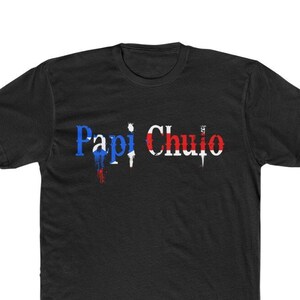 May include: Black t-shirt with the text "Papi Chulo" in white letters with red, white, and blue accents.