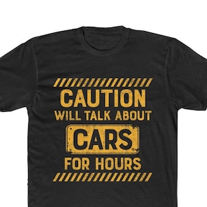 May include: Black t-shirt with yellow text that reads "CAUTION WILL TALK ABOUT CARS FOR HOURS." The text is in a distressed, vintage style. The shirt has a crew neck and short sleeves.