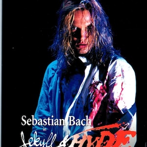 May include: Poster for the musical "Jekyll & Hyde" featuring Sebastian Bach. The image shows a man with long, wet hair and a blood-stained shirt. Text at the top reads "Evil Has Never Looked This Good."