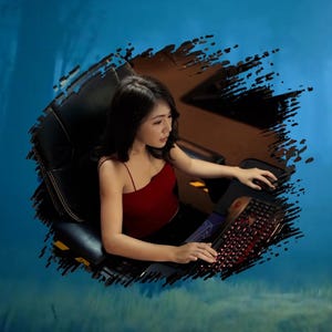 Puede incluir: Una persona con un top rojo y pantalones negros está sentada en una silla de juego negra, usando una computadora. Se ven un teclado y un ratón iluminados en rojo. El fondo es un diseño abstracto azul y marrón.
