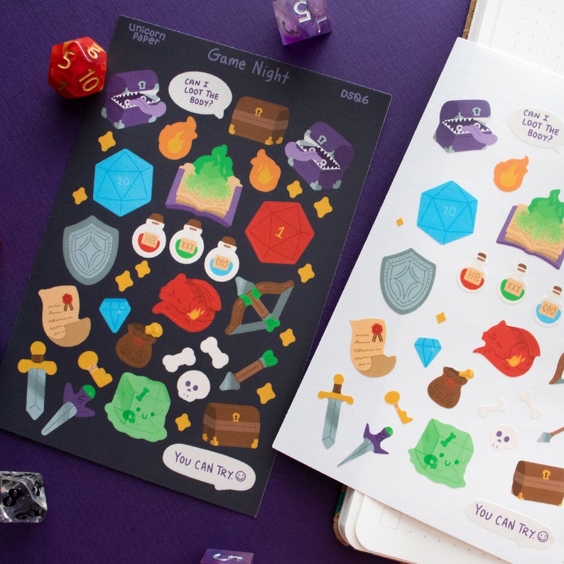 May include: Two sheets of stickers with a black and white background. The stickers are themed around a game night with dice, treasure chests, swords, shields, potions, and other fantasy elements. The text on the stickers reads "Game Night", "Can I loot the body?", and "You can try."