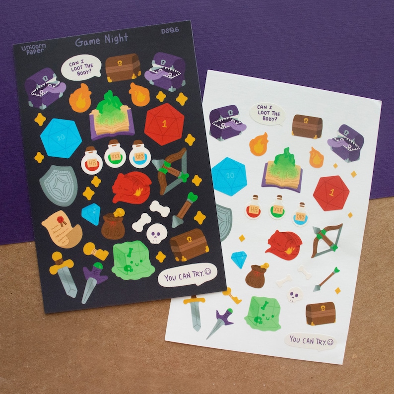 May include: Two sheets of stickers with a fantasy game theme. The stickers are black and white with colorful accents. The stickers feature dice, potions, treasure chests, swords, and other fantasy game elements. The text on the stickers reads "Game Night", "Can I Loot the Body?", and "You Can Try."