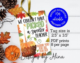 May include: A printable teacher appreciation tag with a fall theme. The tag features a caramel apple with a chocolate drizzle and a heart-shaped candy. The text reads "We couldn't have picked a sweeter teacher. Thank you for all you do!" The tag size is 2.5 inches by 3.5 inches and prints 8 per page.