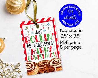 May include: A Christmas gift tag with a red and white striped border, featuring the text "Just Rollin' by to wish you a Merry Christmas!" and an image of cinnamon rolls. The tag is 2.5" x 3.5" and is a printable file.