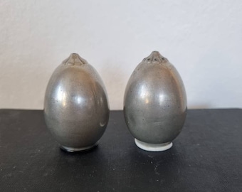 Puede incluir: Un par de saleros y pimenteros de plata en forma de huevo con un diseño decorativo en la parte superior.