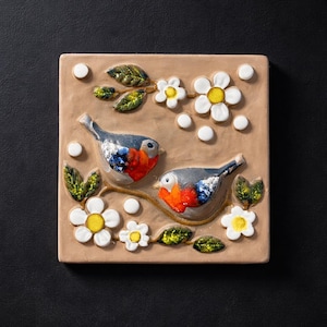 Puede incluir: Una taza de cerámica blanca con un asa negra y el texto "But First, Coffee" en negrita negra. La taza se encuentra sobre un fondo borroso, sugiriendo un ambiente acogedor.