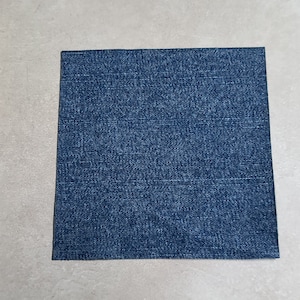 May include: A square piece of blue denim fabric.