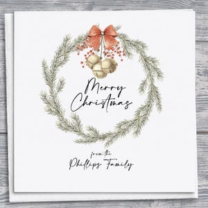 "Personalisierte handgemachte Weihnachtskarte mit Aquarell-Weihnachtskranz und Glocken, die an einer roten Schleife hängen, festliche Weihnachtsgruß-Karte."