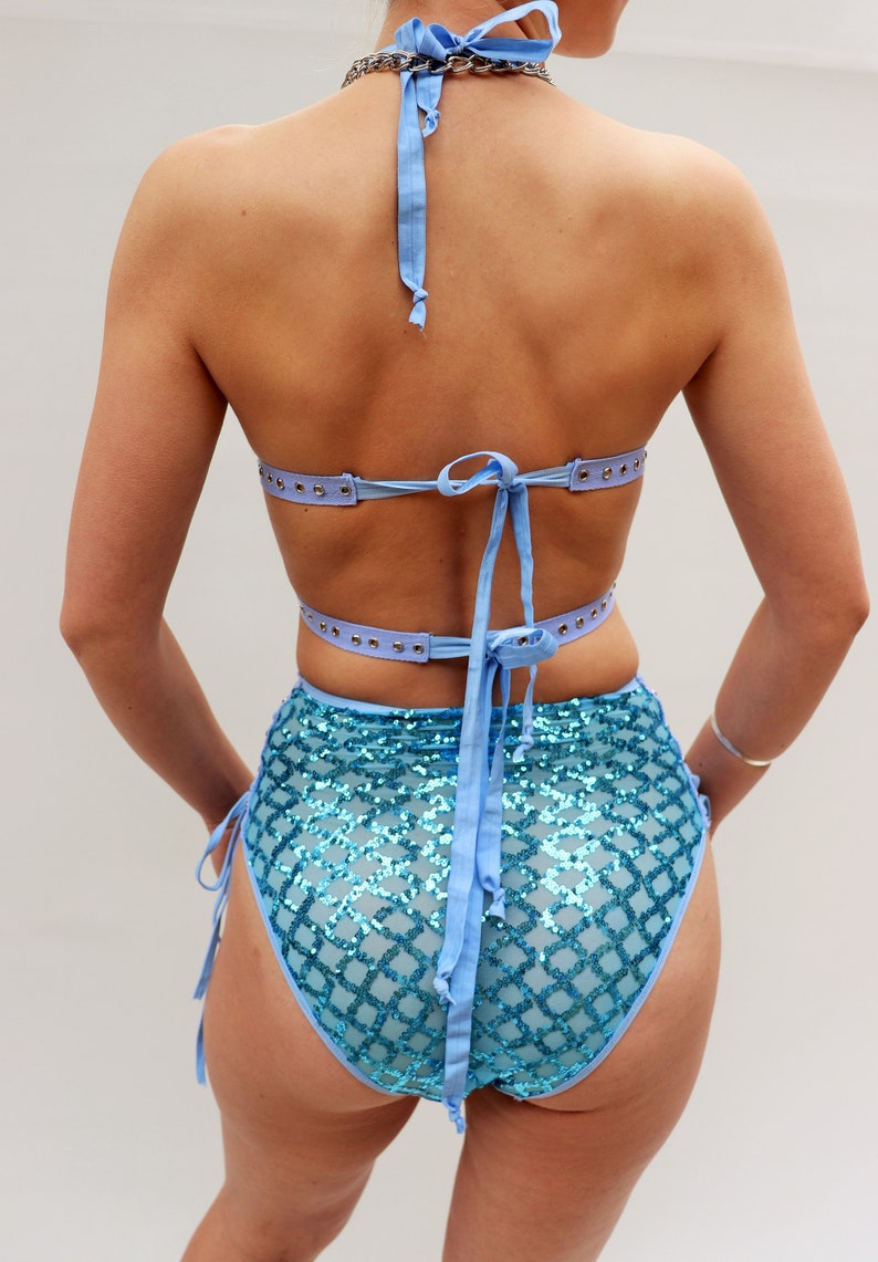 Puede incluir: Un top y una parte inferior de bikini azul claro con un patr&oacute;n de lentejuelas. El top tiene tirantes ajustables y un lazo en la espalda. La parte inferior tiene cintura alta y lazos en los lados.