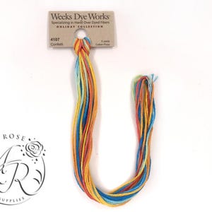 May include: A bundle of colorful cotton floss in shades of orange, yellow, blue, and teal. The floss is labeled "Confetti" from Weeks Dye Works, Holiday Collection. The bundle is approximately 5 yards in length. The Amy Rose Jewelry Supplies logo is in the lower left corner.