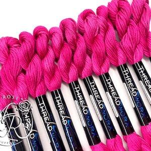 May include: A bundle of ten pink embroidery floss spools with black labels that read "THREADWORX Hand Overdyed Floss".