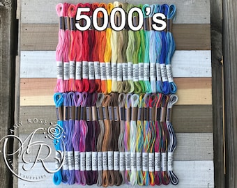 May include: A collection of 40 embroidery floss spools in various colors, including red, orange, yellow, green, blue, purple, brown, and white. The spools are labeled with numbers from 5001 to 5040. The text "5000's" is written in large letters at the top of the image.
