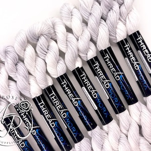 May include: Six spools of white hand-dyed embroidery floss, each with a black label that reads "THREADWORX Hand Overdyed Floss".