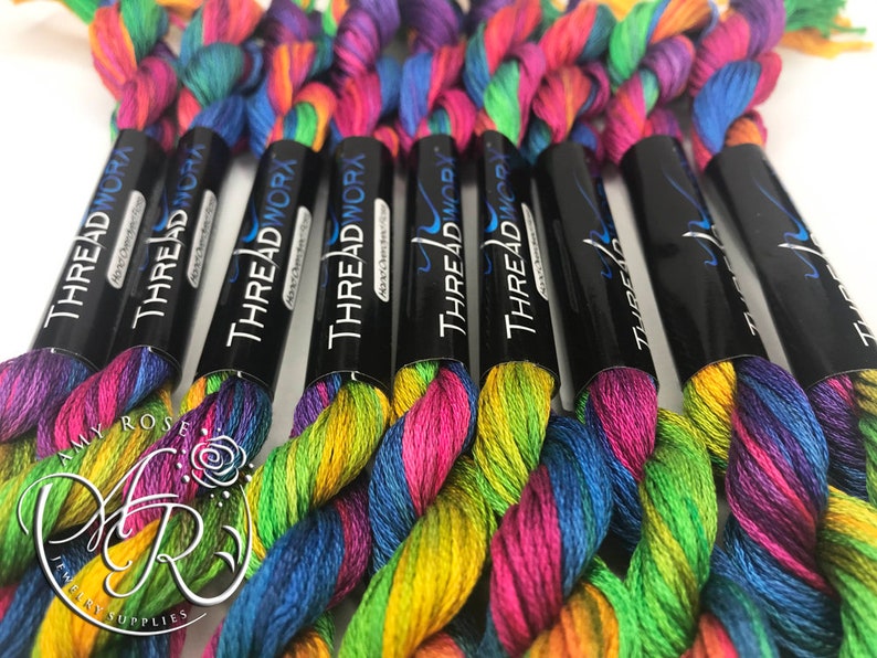 May include: Close-up of six spools of rainbow colored embroidery floss. The spools are labeled "THREAD WORX" and "THREADWORA".