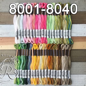 May include: A collection of 40 embroidery floss spools in various colors, including white, pink, green, yellow, and brown. The spools are labeled with numbers from 8001 to 8040.