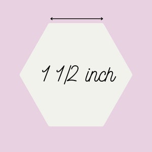 May include: A white hexagon with a black outline and the text "1 1/2 inch" inside. The hexagon is on a light pink background.