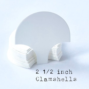 May include: A stack of white, 2 1/2 inch clamshell packaging.