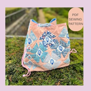 May include: A peach-colored drawstring backpack with patchwork details. The patchwork includes blue and white floral and peacock feather patterns. The bag has a pink drawstring and the text "PDF SEWING PATTERN" on a light peach background.