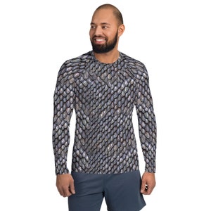 Puede incluir: Camiseta de manga larga con un patrón de escamas plateadas y grises. El diseño cubre toda la camiseta, creando una apariencia texturizada. La camiseta tiene cuello redondo y está hecha de un material suave y cómodo.