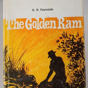 May include: Vintage book cover for "The Golden Ram" by G.H. Fearnside. The cover features a silhouette of a person in a hat, kneeling near foliage, set against a yellow and orange background. The title is in large white letters.